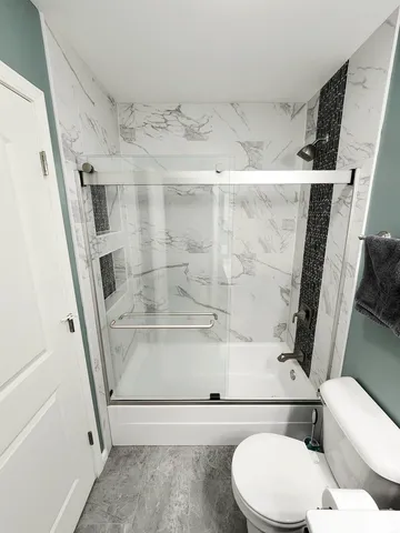 a bathroom with a toilet and a shower