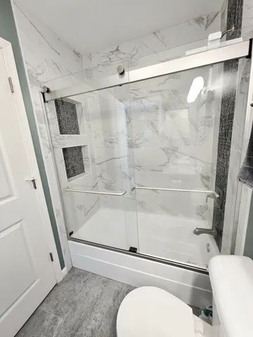 a bathroom with a toilet and a shower
