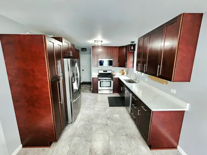 a kitchen with stainless steel appliances granite countertop a refrigerator a stove and a sink