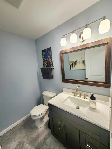 a bathroom with a toilet sink vanity and mirror