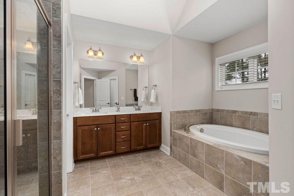 1217 Harrison Ridge Road Wake Forest, NC 27587 - Photo 14 of 30 a spacious bathroom with a tub sink and mirror