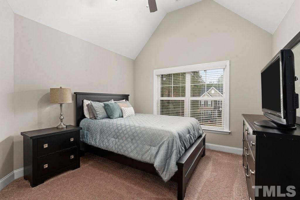 1217 Harrison Ridge Road Wake Forest, NC 27587 - Photo 15 of 30 a bedroom with a bed and a flat tv screen on a dresser