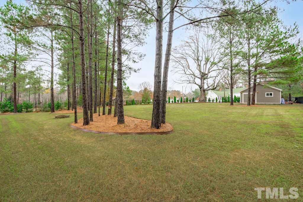 1217 Harrison Ridge Road Wake Forest, NC 27587 - Photo 25 of 30 a view of a tree in front of a white house