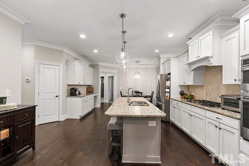 1217 Harrison Ridge Road Wake Forest, NC 27587 - Photo 7 of 30 a large kitchen with kitchen island white cabinets and stainless steel appliances