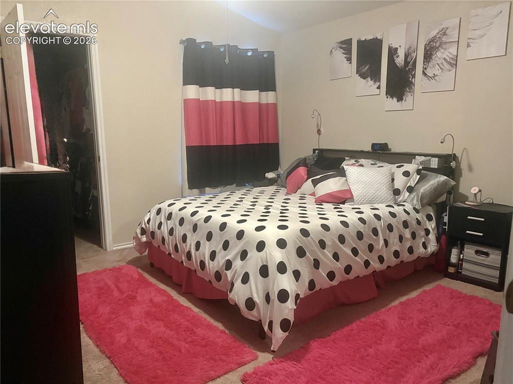 3748 Riviera Grove, Unit 203 Colorado Springs, CO 80922 - Photo 17 of 23 a bedroom with a bed and dresser with mirror