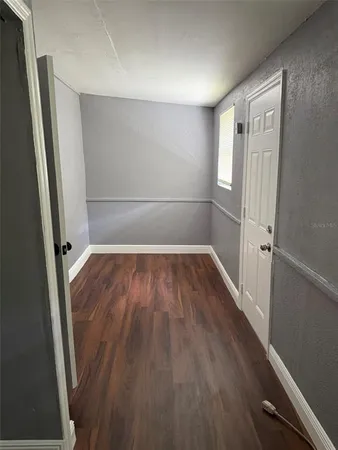 a view of a room with wooden floor and entryway