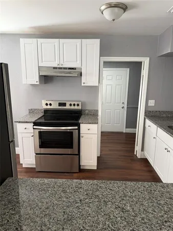 a kitchen with granite countertop a stove and a sink