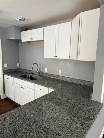 a kitchen with a refrigerator sink and cabinets