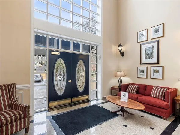 a living room with furniture a rug and a wall painting
