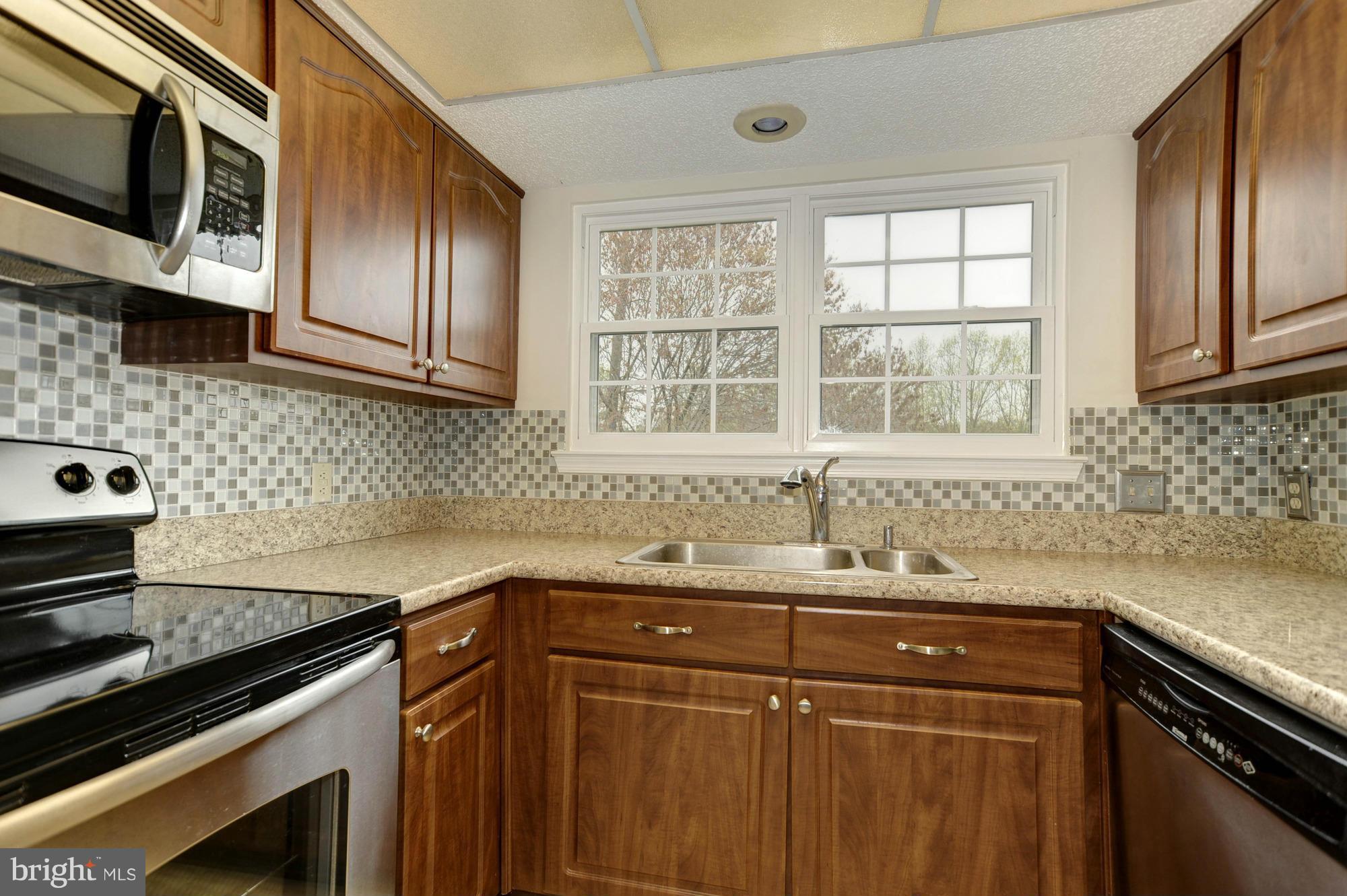 12000 Golf Ridge Court, Unit 352 Fairfax, VA 22033 - Photo 11 of 29 a kitchen with stainless steel appliances a sink stove and cabinets