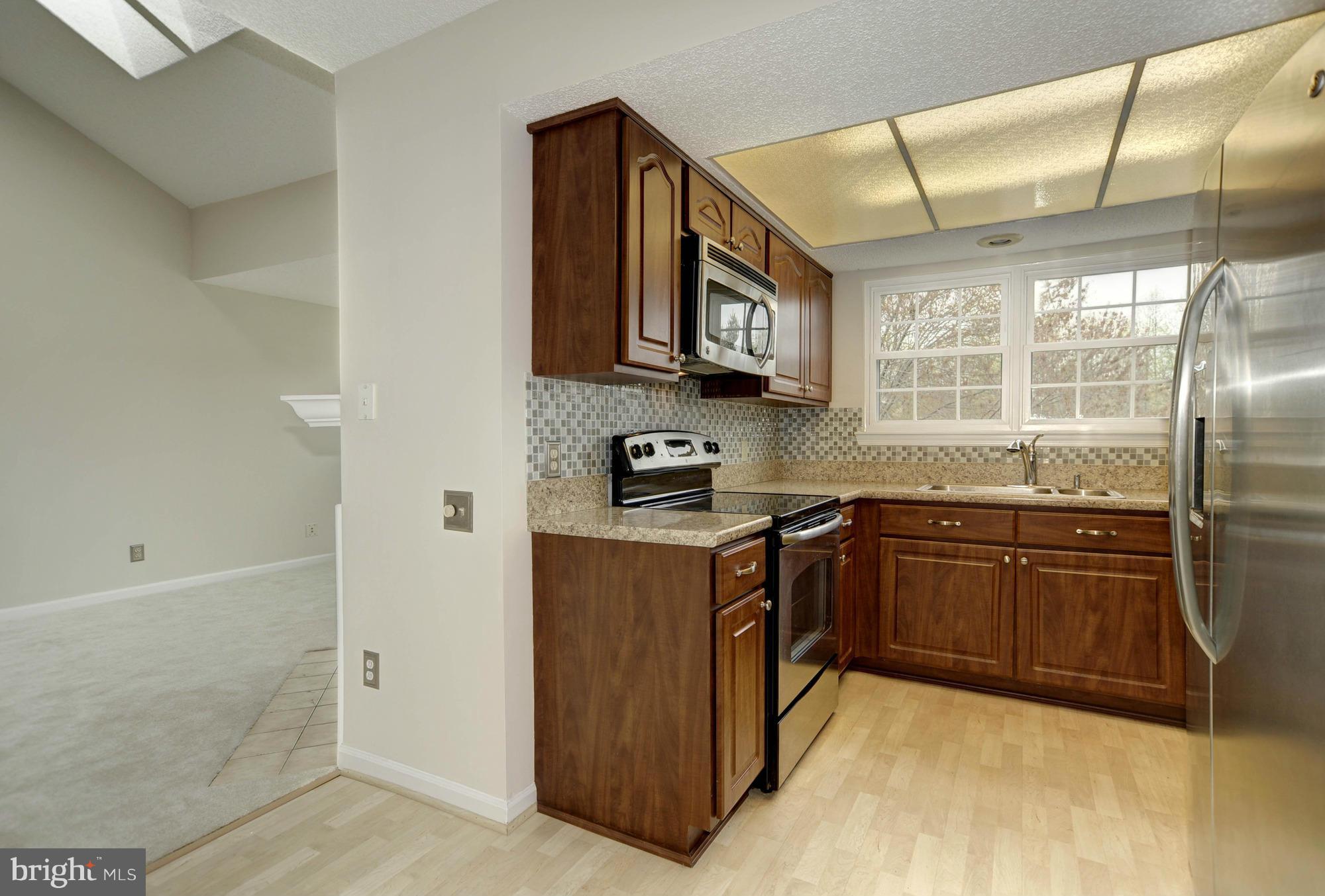 12000 Golf Ridge Court, Unit 352 Fairfax, VA 22033 - Photo 12 of 29 a kitchen with stainless steel appliances granite countertop a stove a sink and a refrigerator