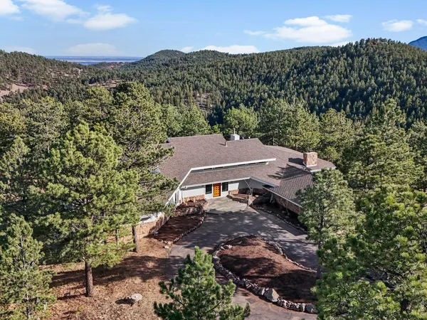 an aerial view of a house with a mountain