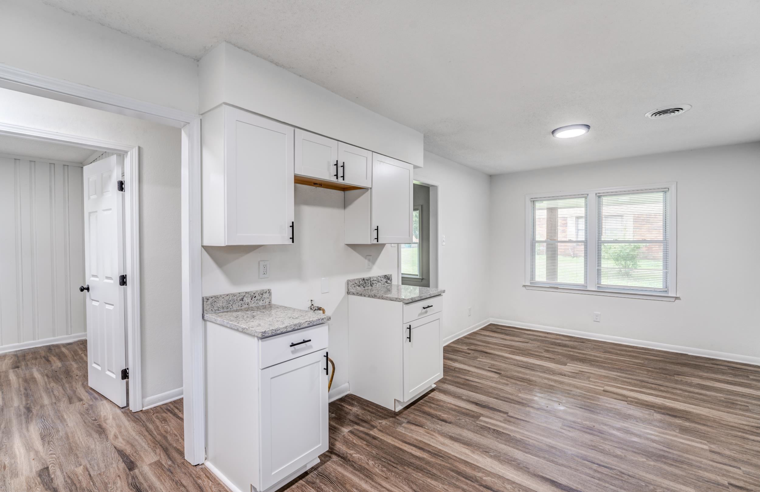 5341 Millbranch Road Memphis, TN 38116 - Photo 12 of 29 a kitchen with a stove a refrigerator and white cabinets with wooden floor