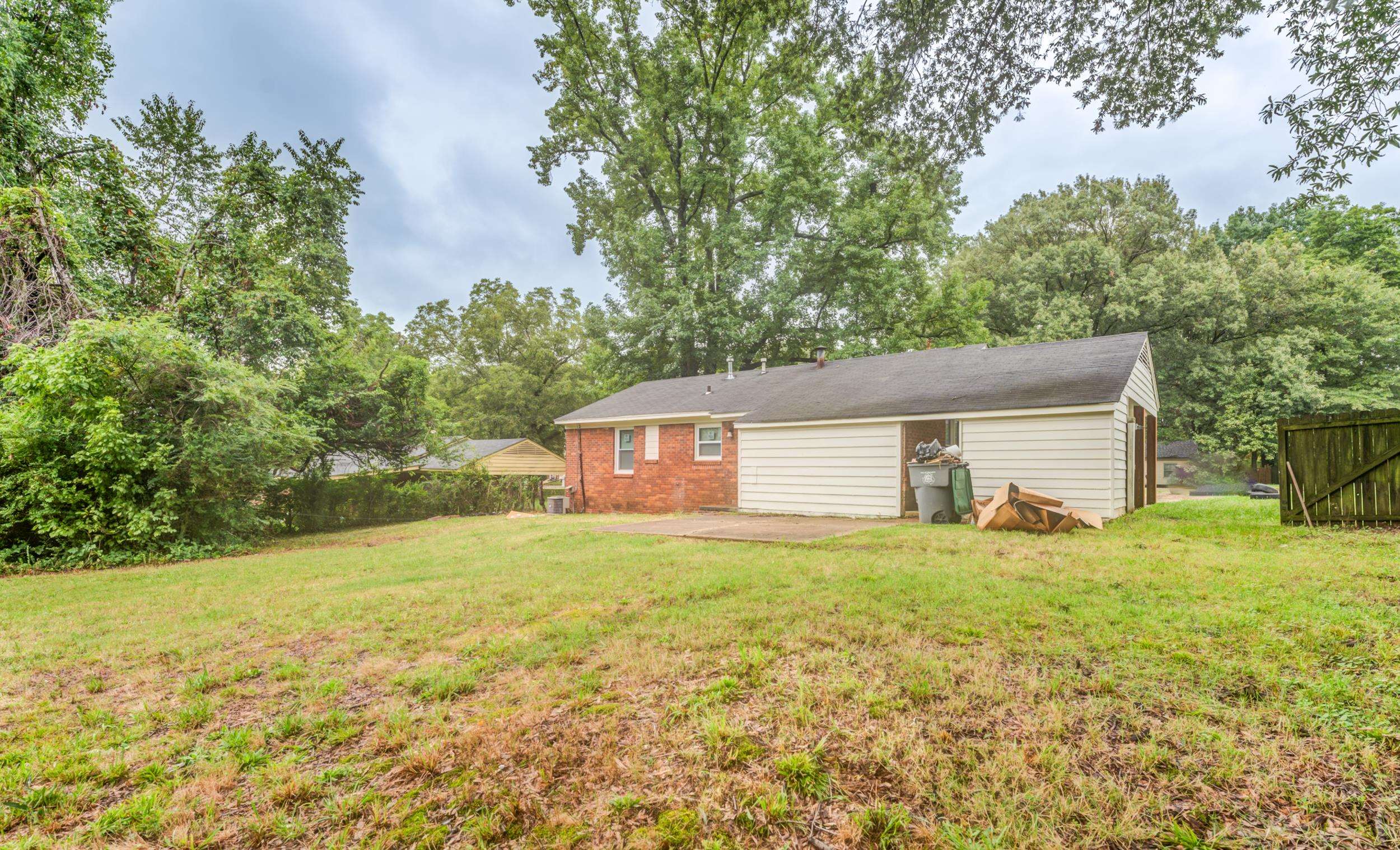 5341 Millbranch Road Memphis, TN 38116 - Photo 24 of 29 a house that is sitting in the grass with large trees