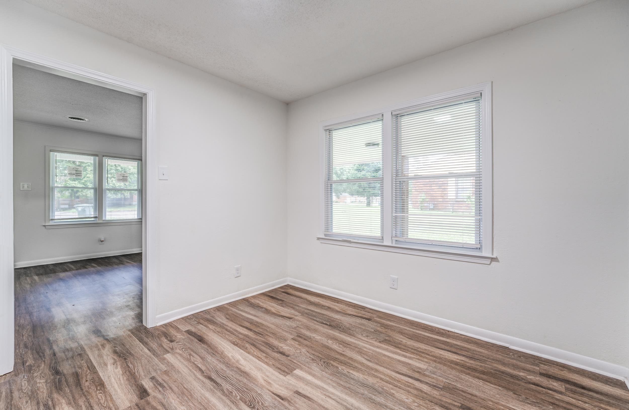 5341 Millbranch Road Memphis, TN 38116 - Photo 9 of 29 an empty room with wooden floor and windows