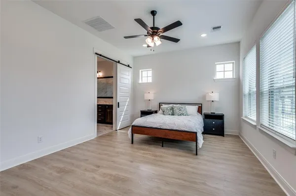 a bedroom with a large bed chandelier and a window