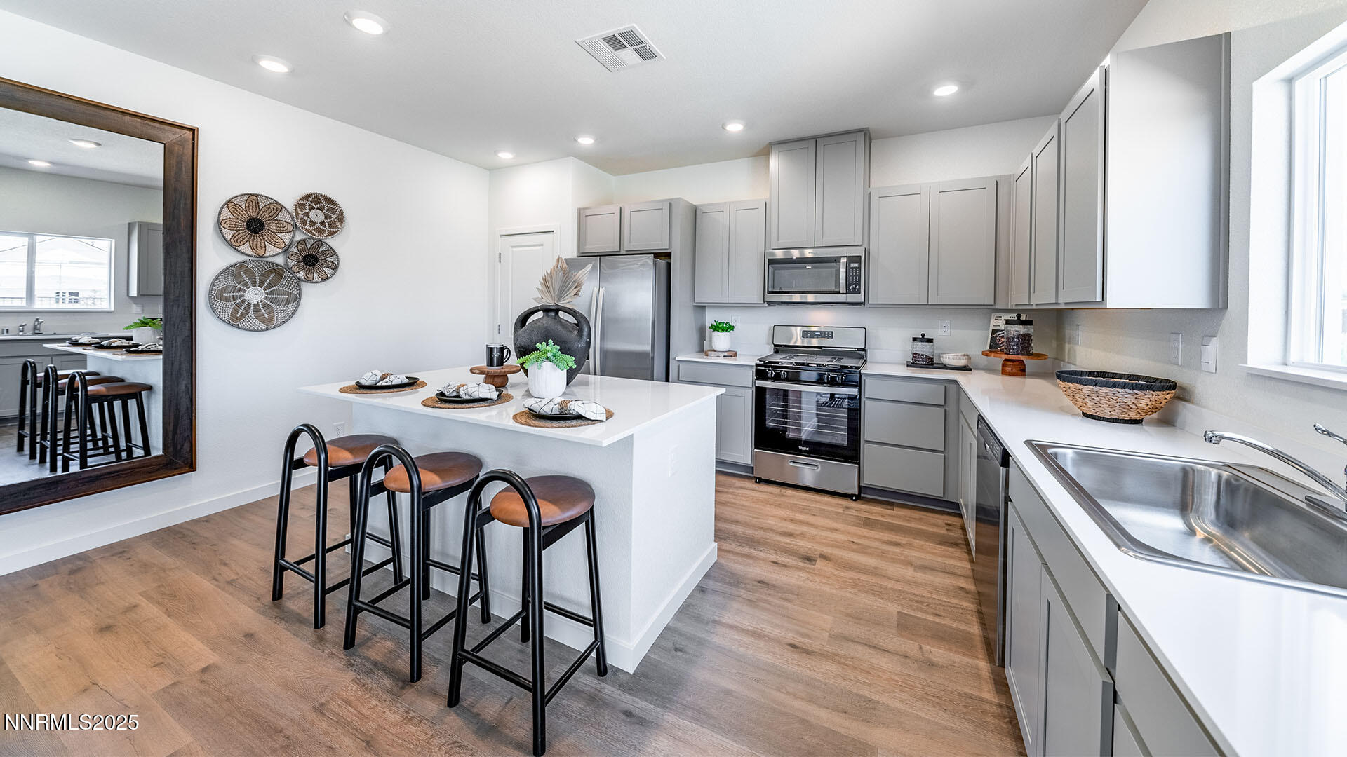 7489 Capstone Drive Reno, NV 89506 - Photo 7 of 25 a kitchen with kitchen island granite countertop a sink a stove a refrigerator cabinets and a dining table