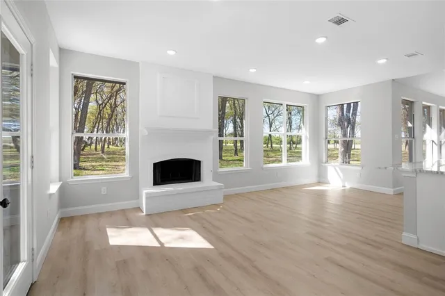 a view of an empty room with window and fire place