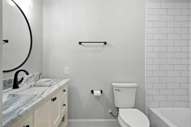 a spacious bathroom with a double vanity sink a large mirror and a bathtub
