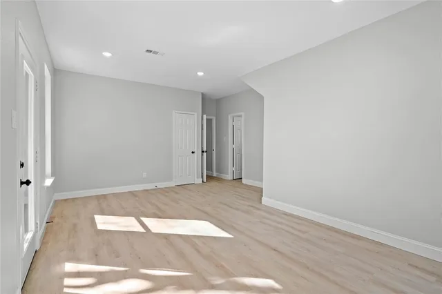 an empty room with a ceiling fan and window