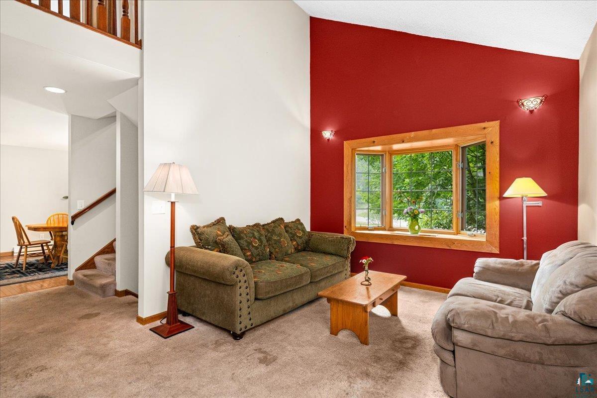 5195 Lavaque Junction Road Hermantown, MN 55811 - Photo 19 of 66 Living area featuring a bay window with natural wood trim, vaulted ceiling, and architectural wall sconces