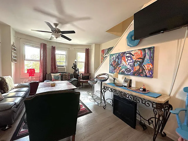 a living room with furniture a flat screen tv and a window