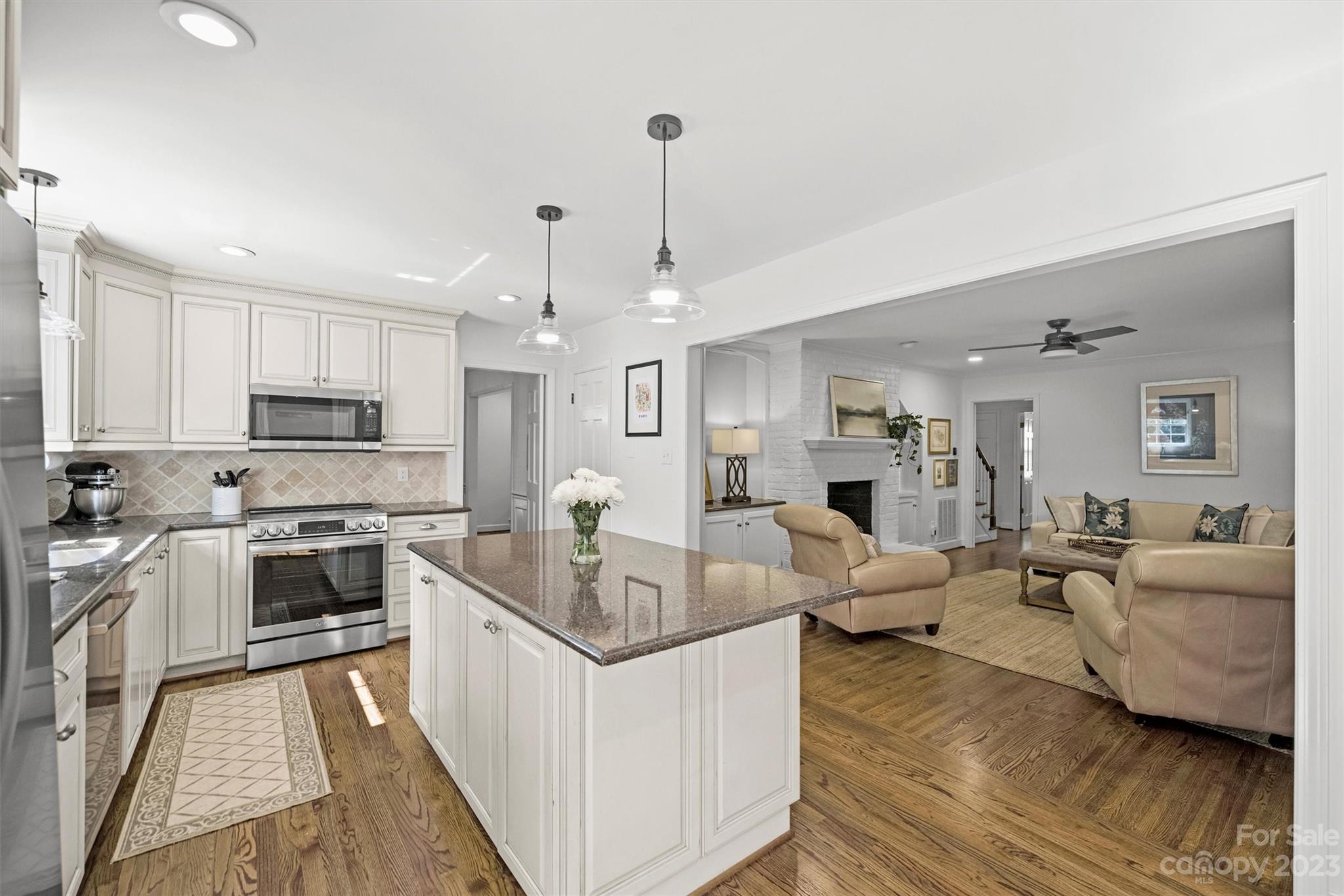 5943 Brace Road Charlotte, NC 28211 - Photo 13 of 36 a large kitchen with white cabinets and stainless steel appliances