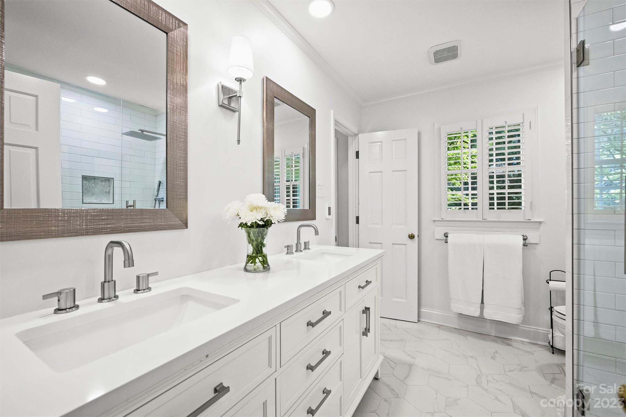 5943 Brace Road Charlotte, NC 28211 - Photo 25 of 36 a bathroom with a double vanity sink a mirror and a