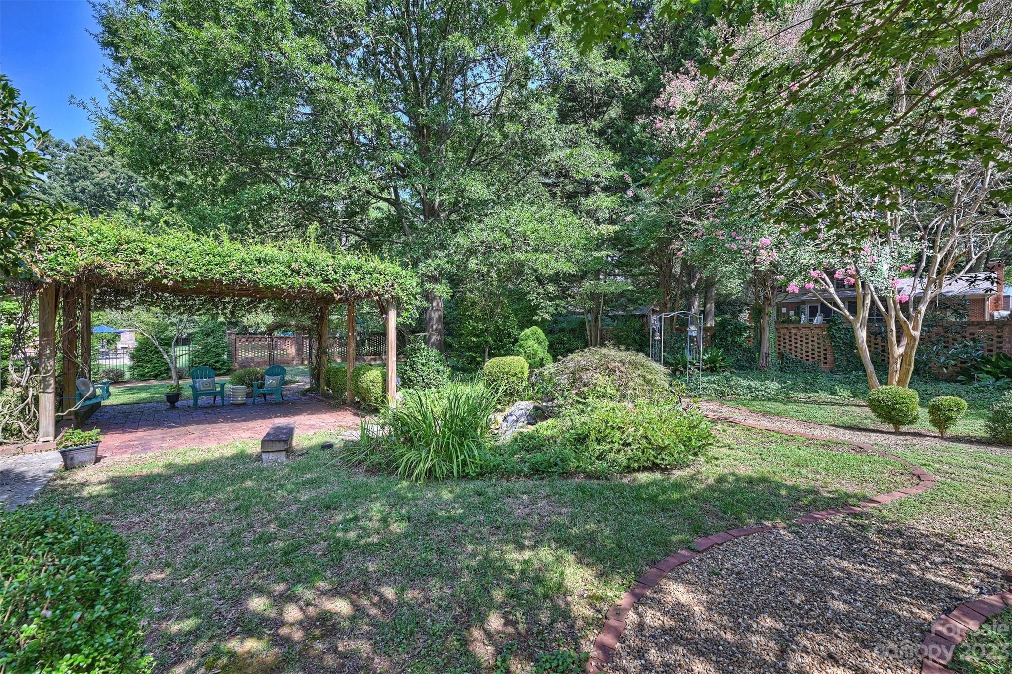 5943 Brace Road Charlotte, NC 28211 - Photo 31 of 36 a view of a backyard with table and chairs and a large tree