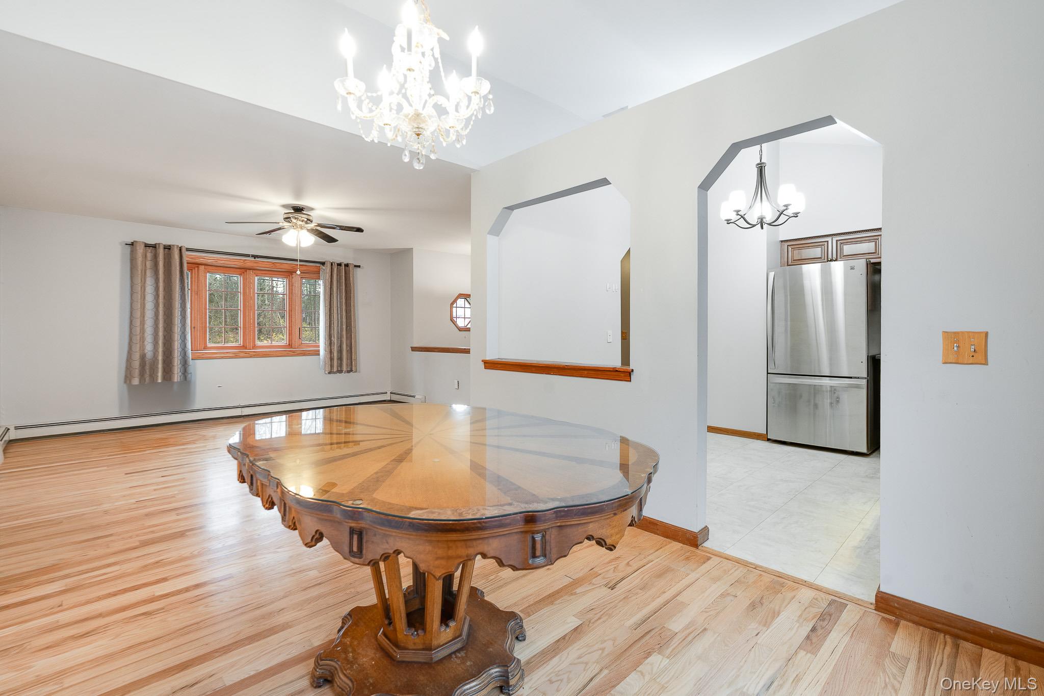 1 Mountain View Road Fishkill, NY 12524 - Photo 5 of 35 a dining room with wooden floor a chandelier a wooden table and chairs