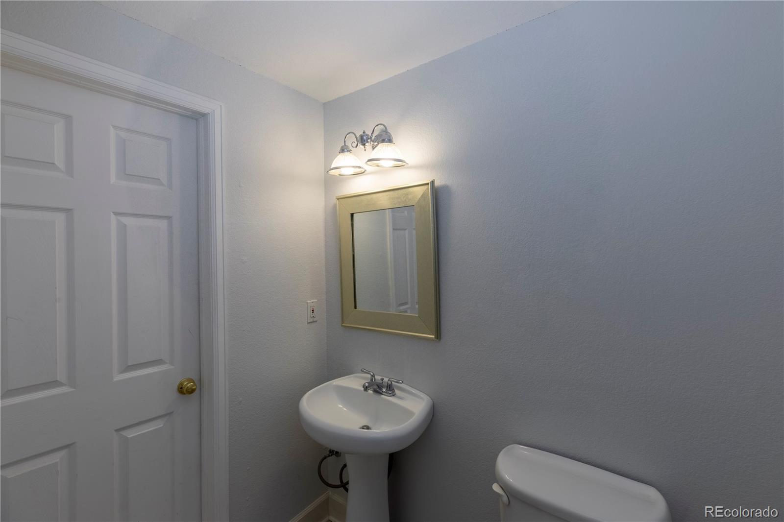 294 West Willowick Circle Highlands Ranch, CO 80129 - Photo 25 of 37 a bathroom with a toilet sink and mirror