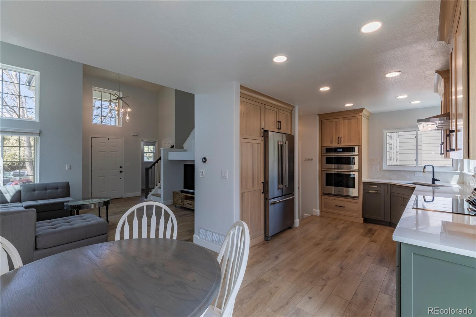 294 West Willowick Circle Highlands Ranch, CO 80129 - Photo 7 of 37 a kitchen with stainless steel appliances granite countertop a refrigerator a stove a sink a microwave a dining table and chairs with wooden floor