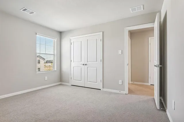 an empty room with windows and closet