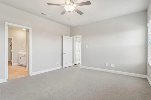 an empty room with a window and a ceiling fan