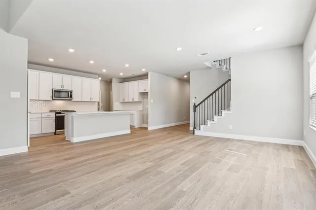 a view of a kitchen with wooden floor and electronic appliances