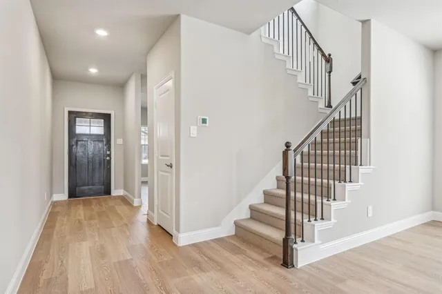 a view of a hallway with wooden floor and entryway