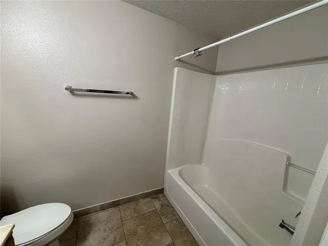 a bathroom with a white bath tub and a toilet