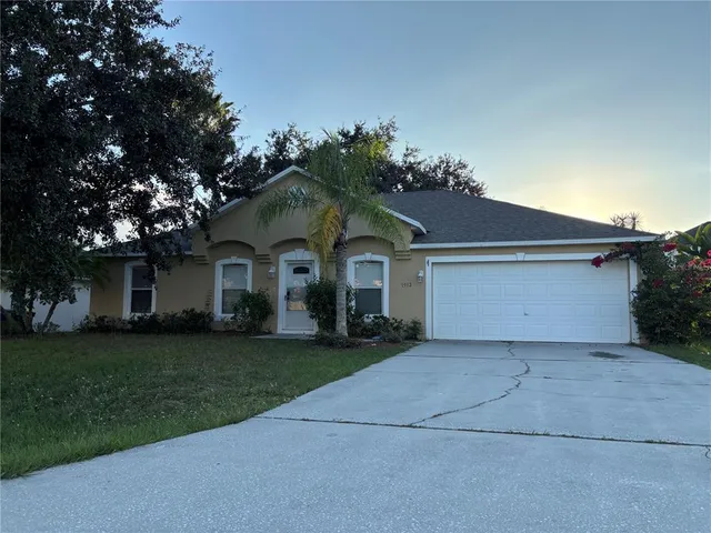 a front view of a house with a garden and trees