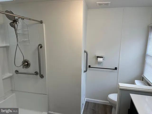 a bathroom with a shower a toilet and a sink