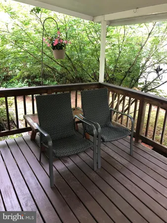 a view of balcony with wooden floor and outdoor seating