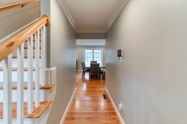 a view of a hallway with wooden floor and staircase