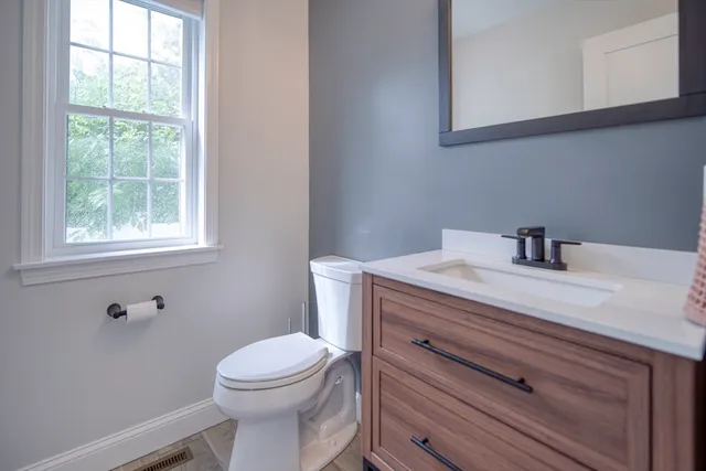 a bathroom with a sink a toilet and a window