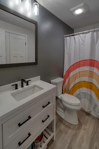 a bathroom with a sink a toilet and a mirror