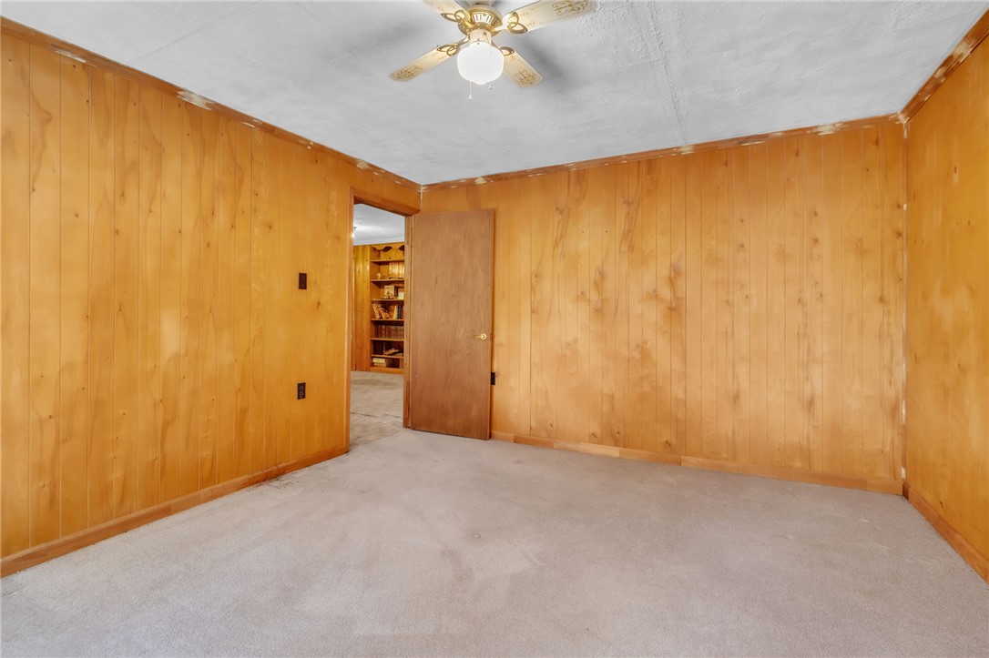 602 Harper Road Pendleton, SC 29670 - Photo 13 of 32 A versatile room featuring natural wood paneling and soft carpeting, ideal for a study or cozy retreat.