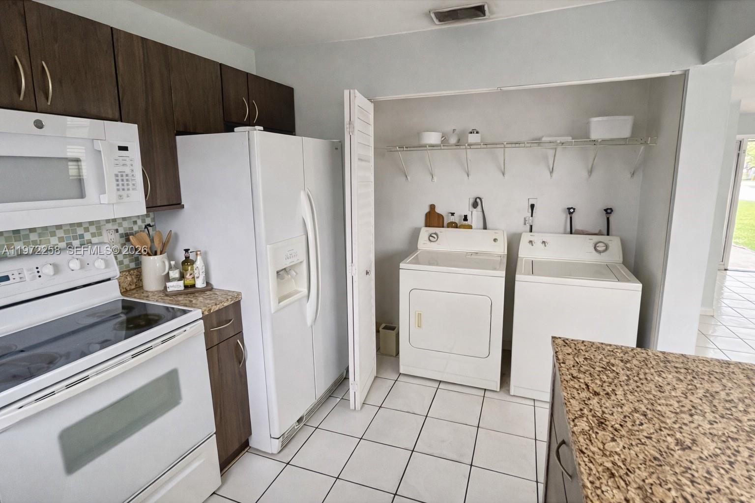 10900 Northwest 7th Street, Unit 101 Miami, FL 33172 - Photo 3 of 10 a utility room with cabinets washer and dryer
