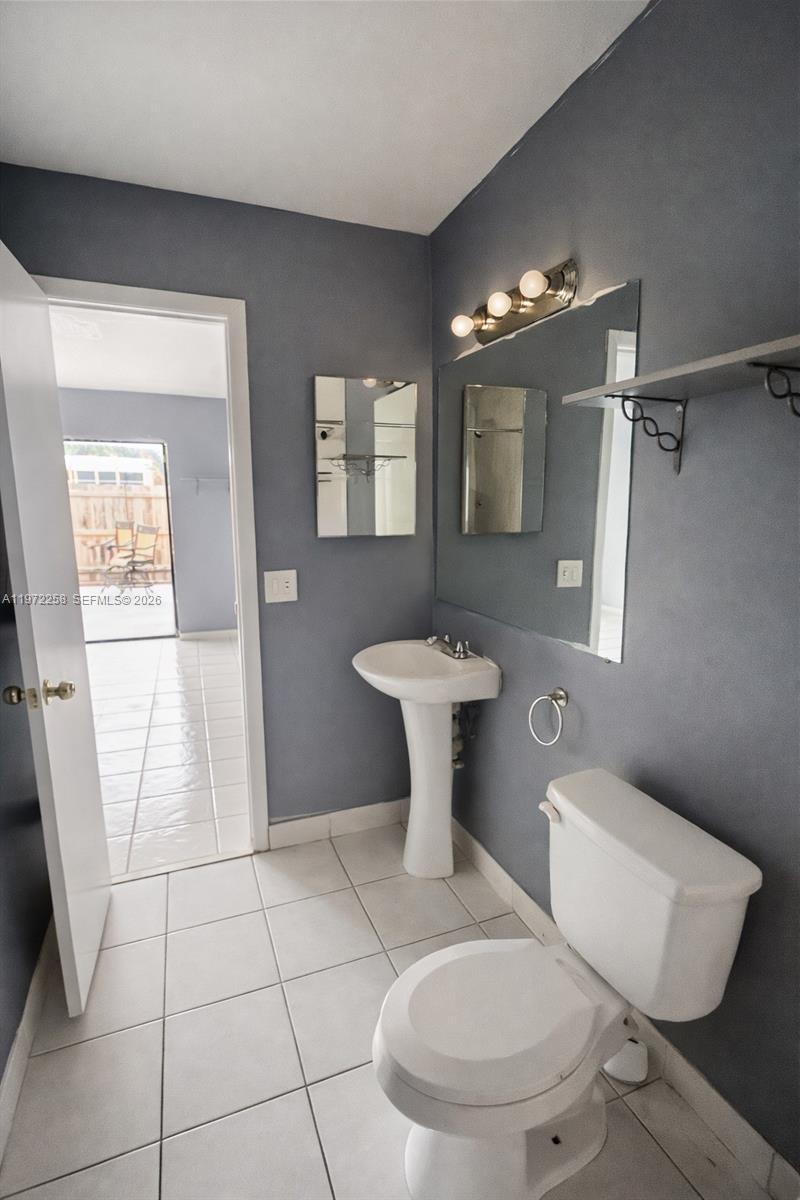 10900 Northwest 7th Street, Unit 101 Miami, FL 33172 - Photo 4 of 10 a bathroom with a toilet sink and mirror