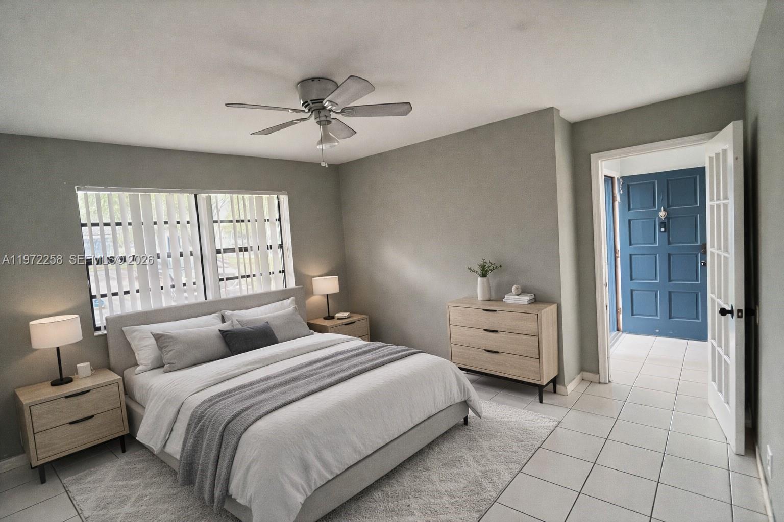 10900 Northwest 7th Street, Unit 101 Miami, FL 33172 - Photo 6 of 10 a bedroom with a bed and a large window