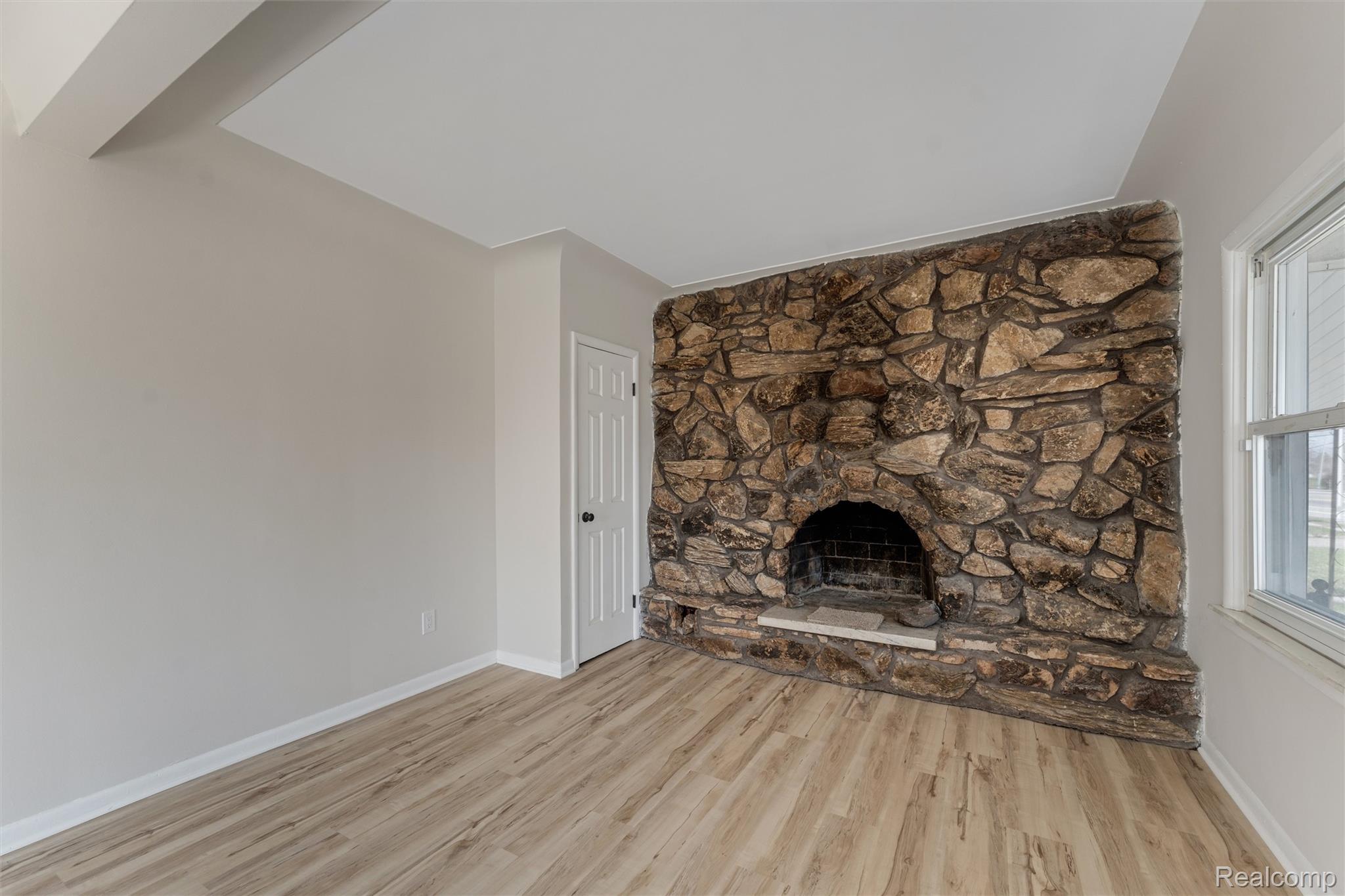 917 Perry Street Pontiac, MI 48340 - Photo 7 of 37 Unfurnished living room featuring a fireplace and light wood-style flooring
