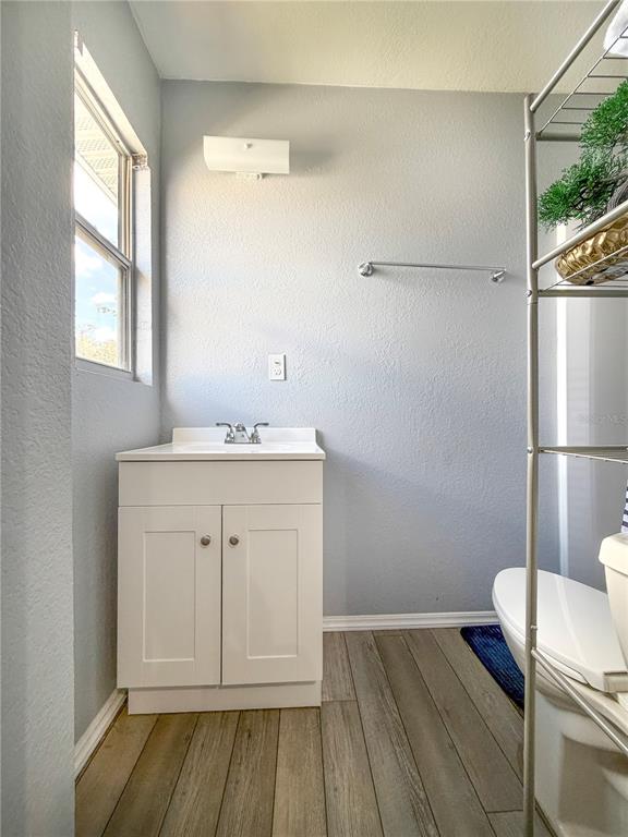 141 South Hiawassee Road Orlando, FL 32835 - Photo 19 of 30 a bathroom with a sink a toilet a window and vanity