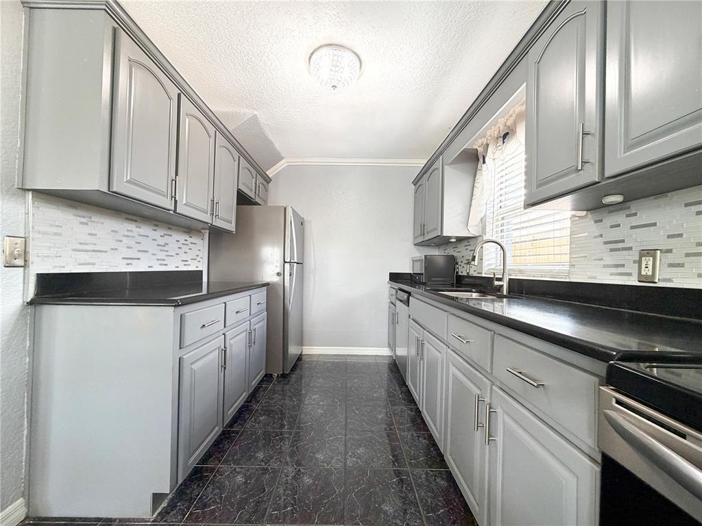 141 South Hiawassee Road Orlando, FL 32835 - Photo 7 of 30 a kitchen with granite countertop white cabinets and stainless steel appliances